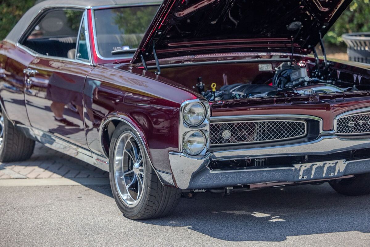 Front three-quarter view of the maroon Pontiac GTO, hood raised over a modern crate engine