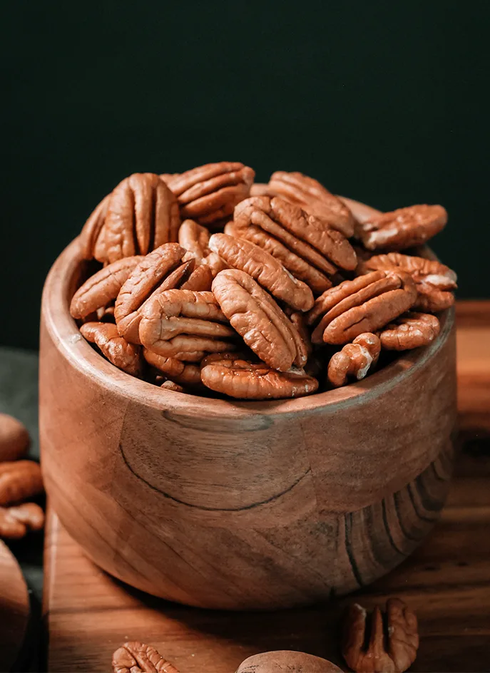 A wooden bowl of Georgia pecan halves